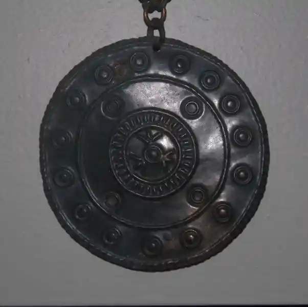 Four-pointed solar disk engraved on a pendant